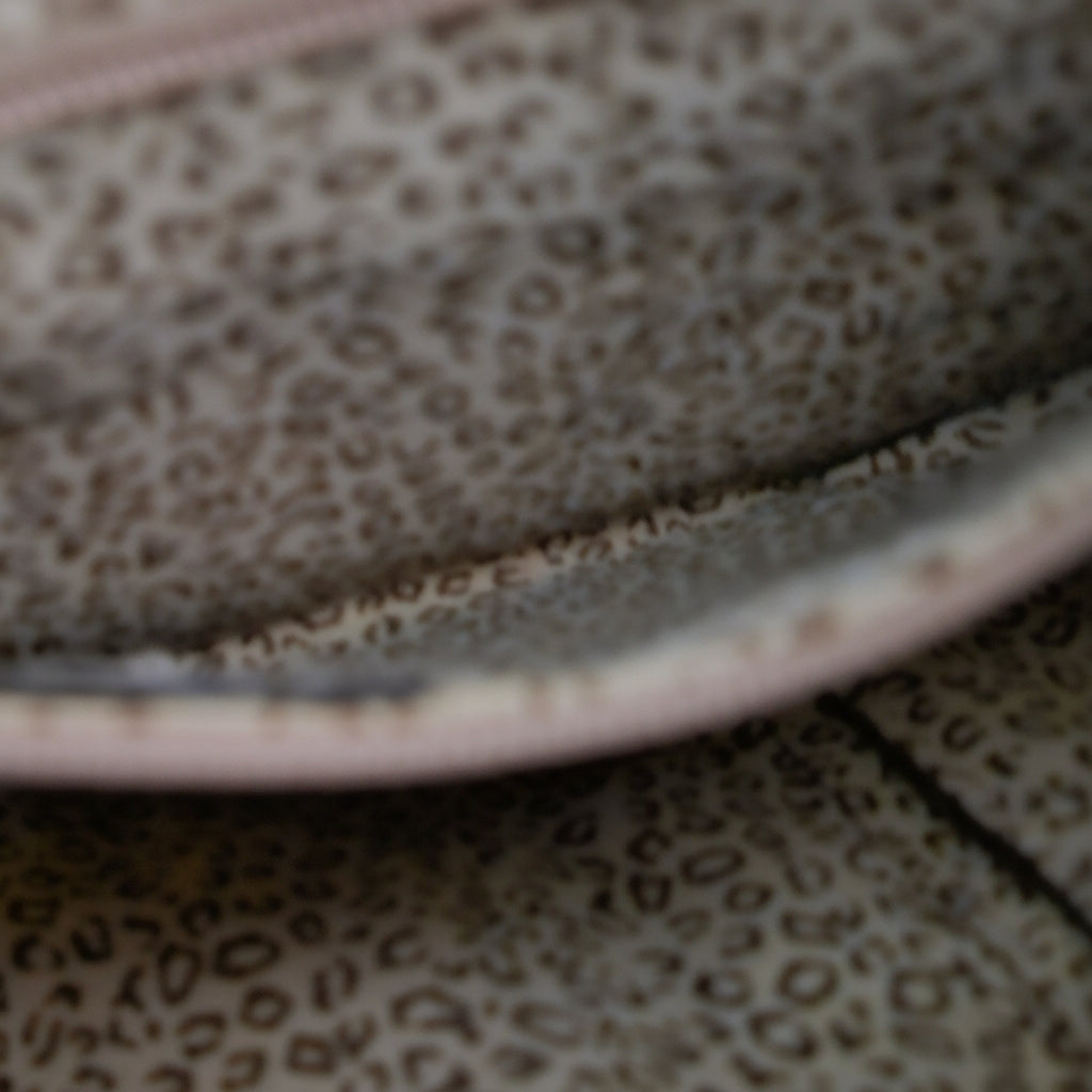 Close-up of a leopard print fabric with a pink border.