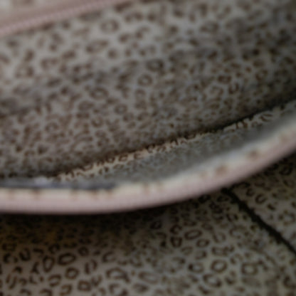 Close-up of a leopard print fabric with a pink border.