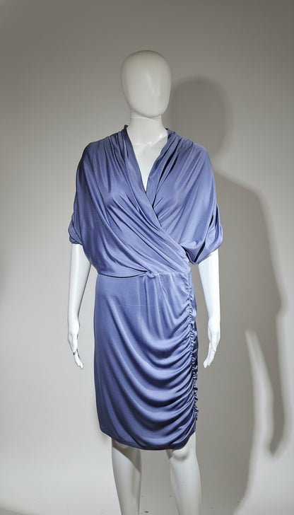 Mannequin wearing a blue draped dress against a plain background