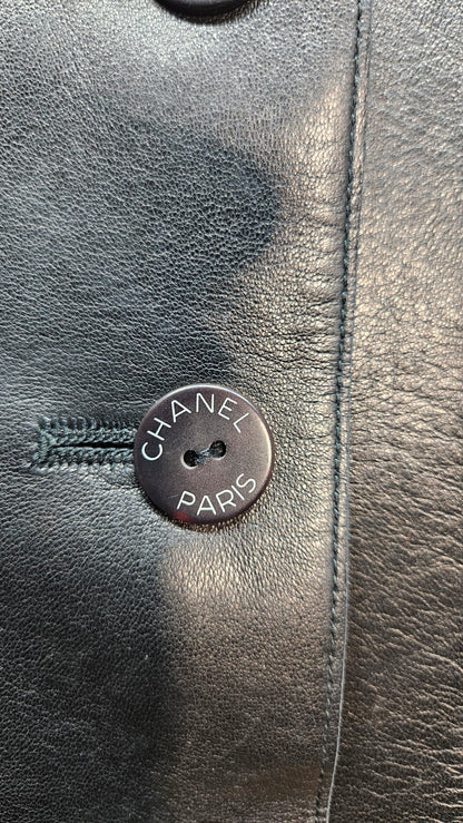 Close-up of a Chanel button on a black leather surface