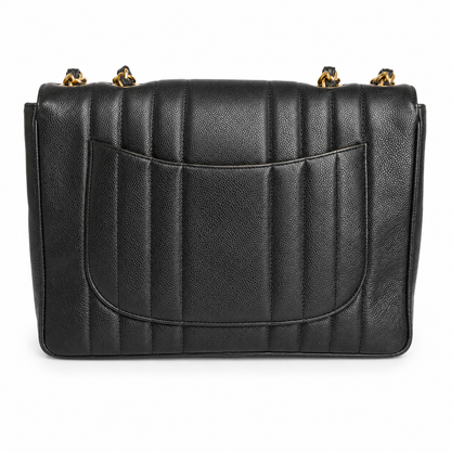 Black quilted handbag with gold hardware on a white background