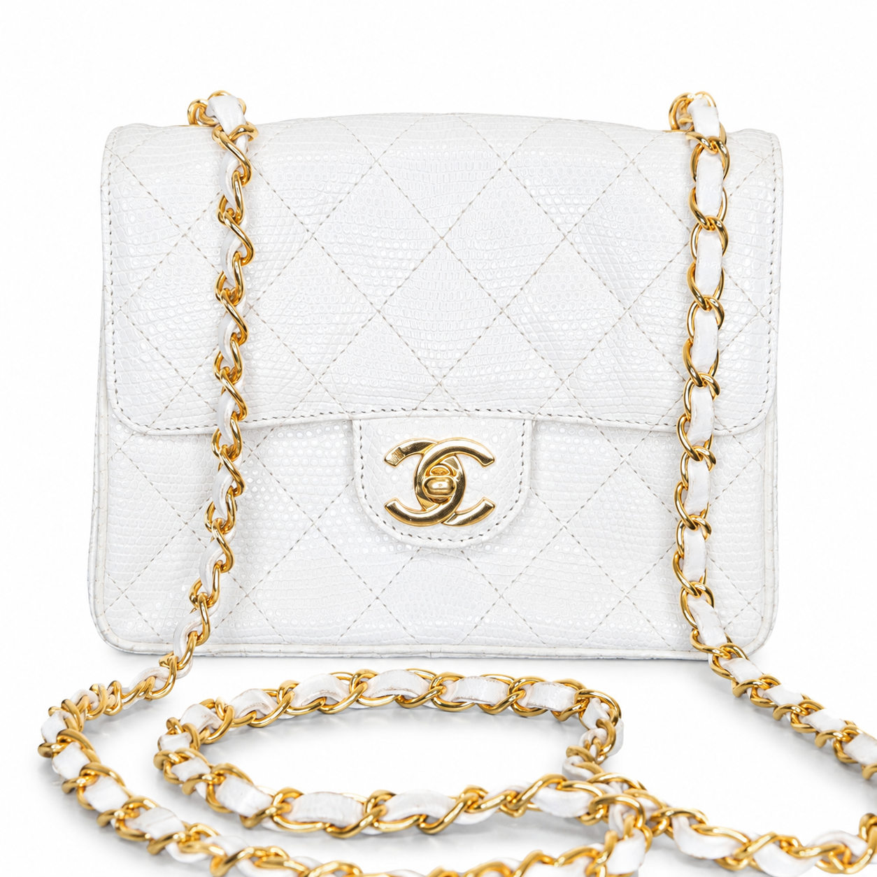 White quilted handbag with gold chain strap on a white background