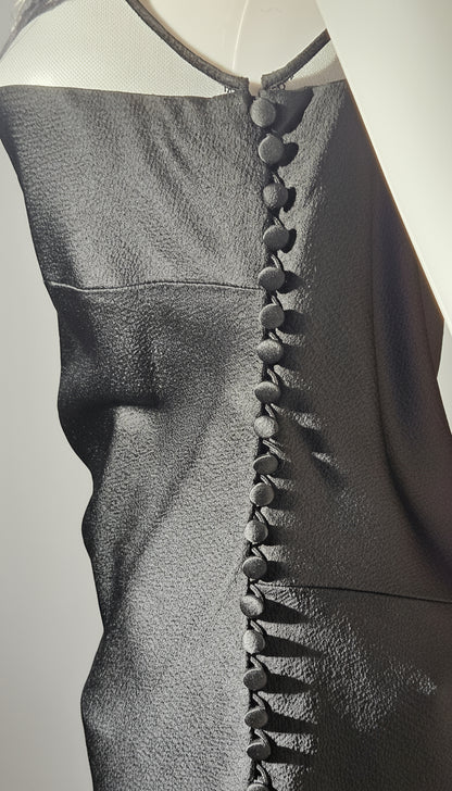 Close-up of a dark gray sleeveless top with button details on a light gray background
