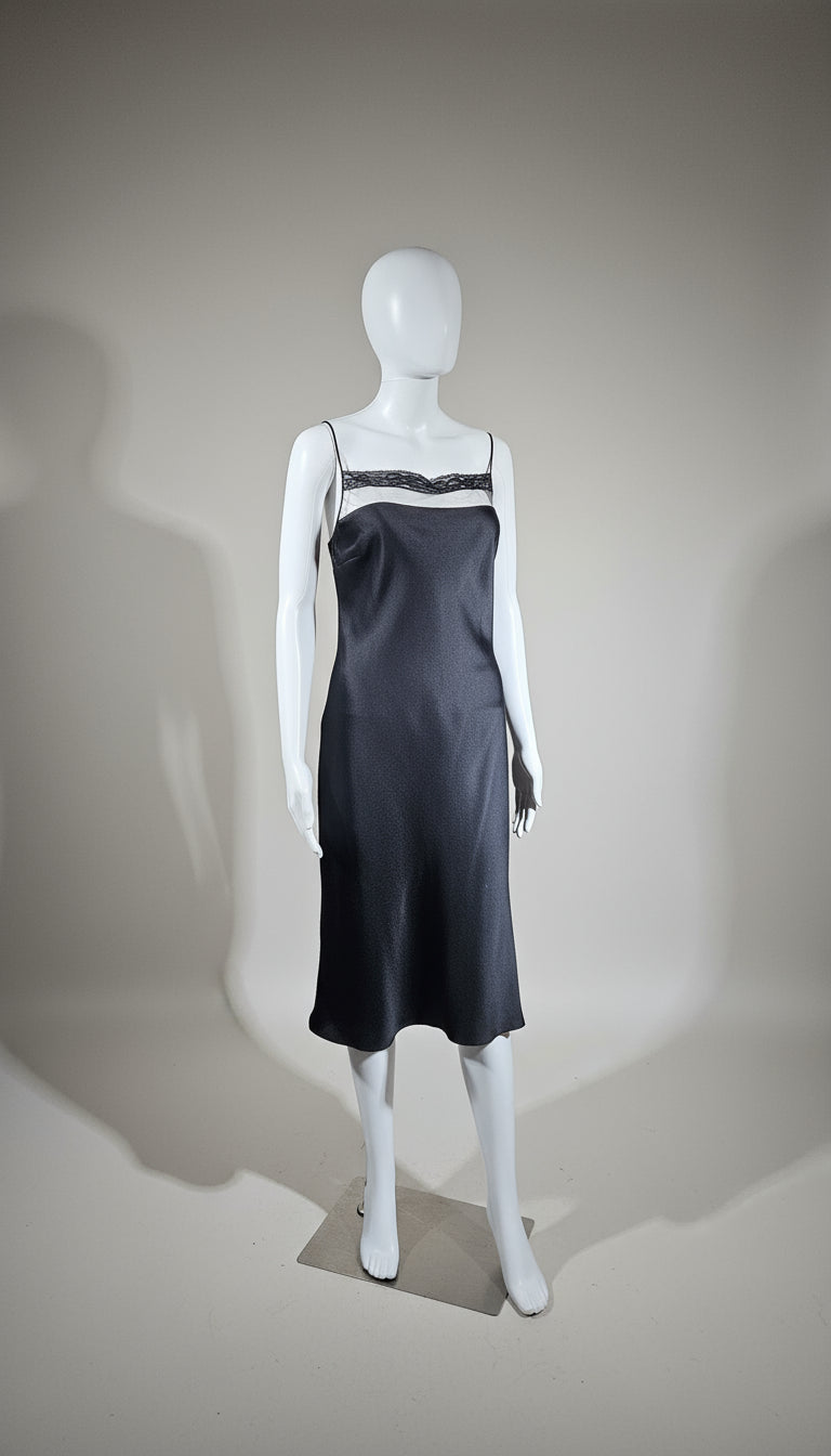Mannequin wearing a black slip dress on a neutral background