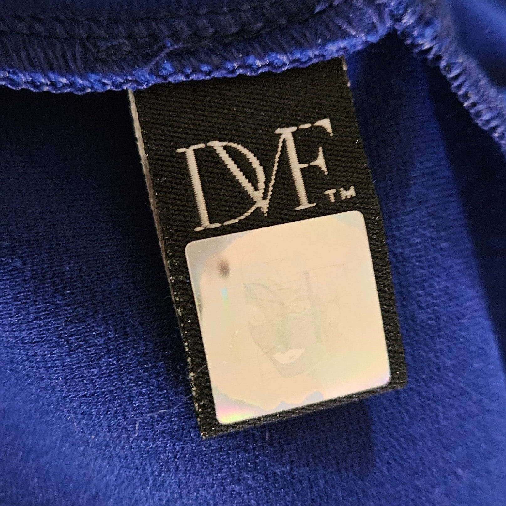 Close-up of a blue fabric with a visible label on a blurred background