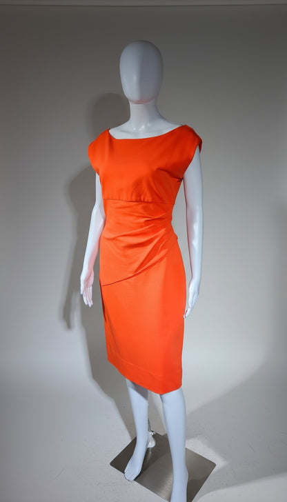 Orange dress on a mannequin against a plain background
