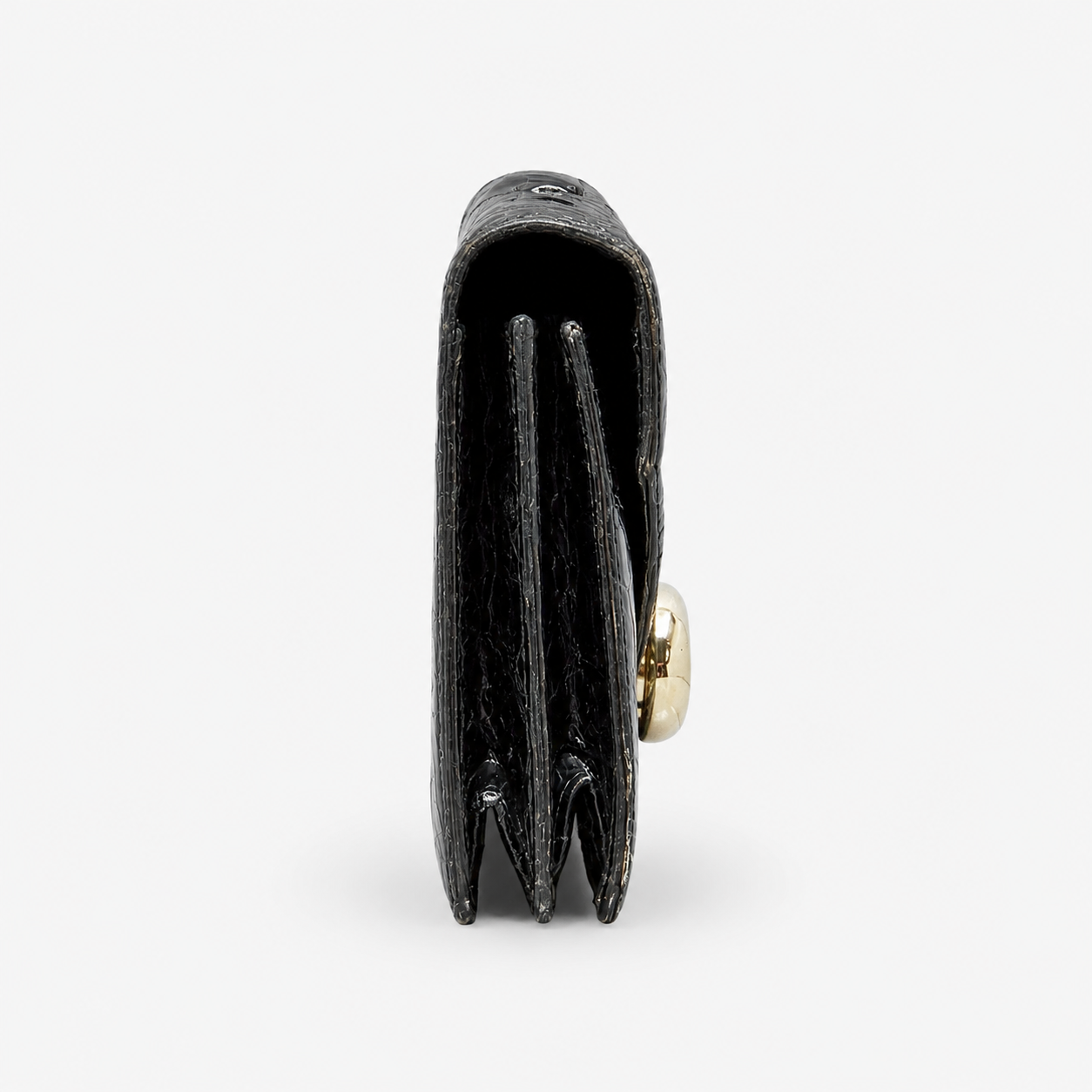 Black leather handbag side view with light damage with gold clasp on a white background