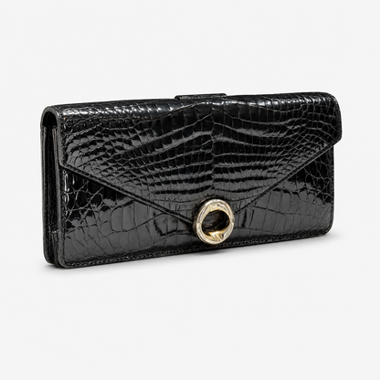 Black crocodile-patterned clutch handbag with a gold clasp on a white background