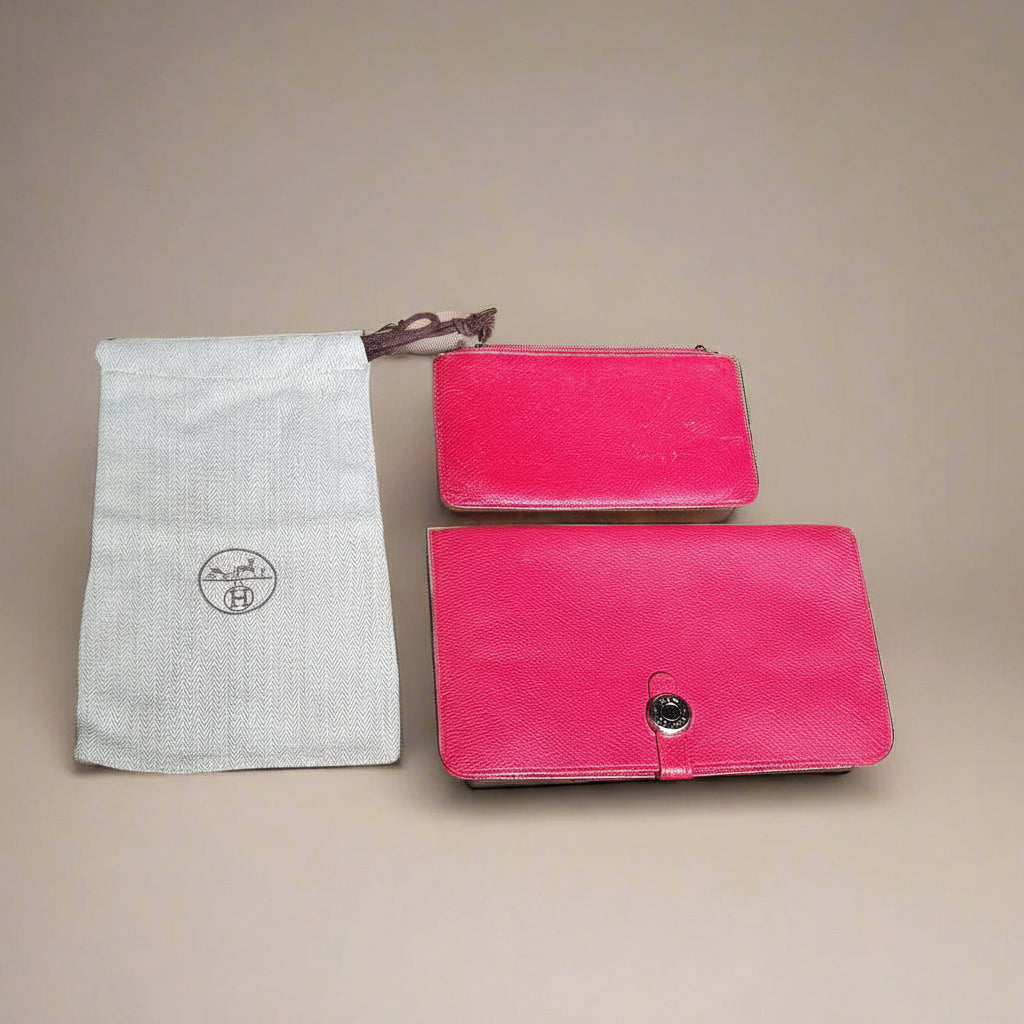 Two red leather pouches with a white drawstring bag on a beige background