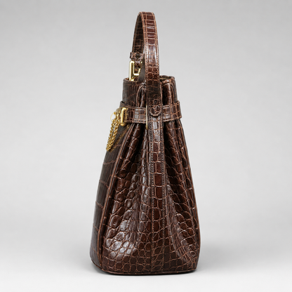 Brown textured handbag with a gold clasp on a light gray background