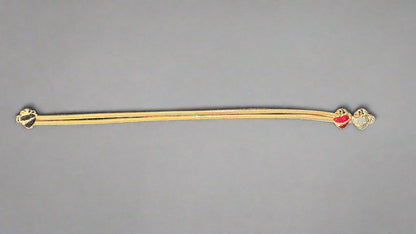 Gold belt with a 3 piece gemstone heart buckle on a gray background