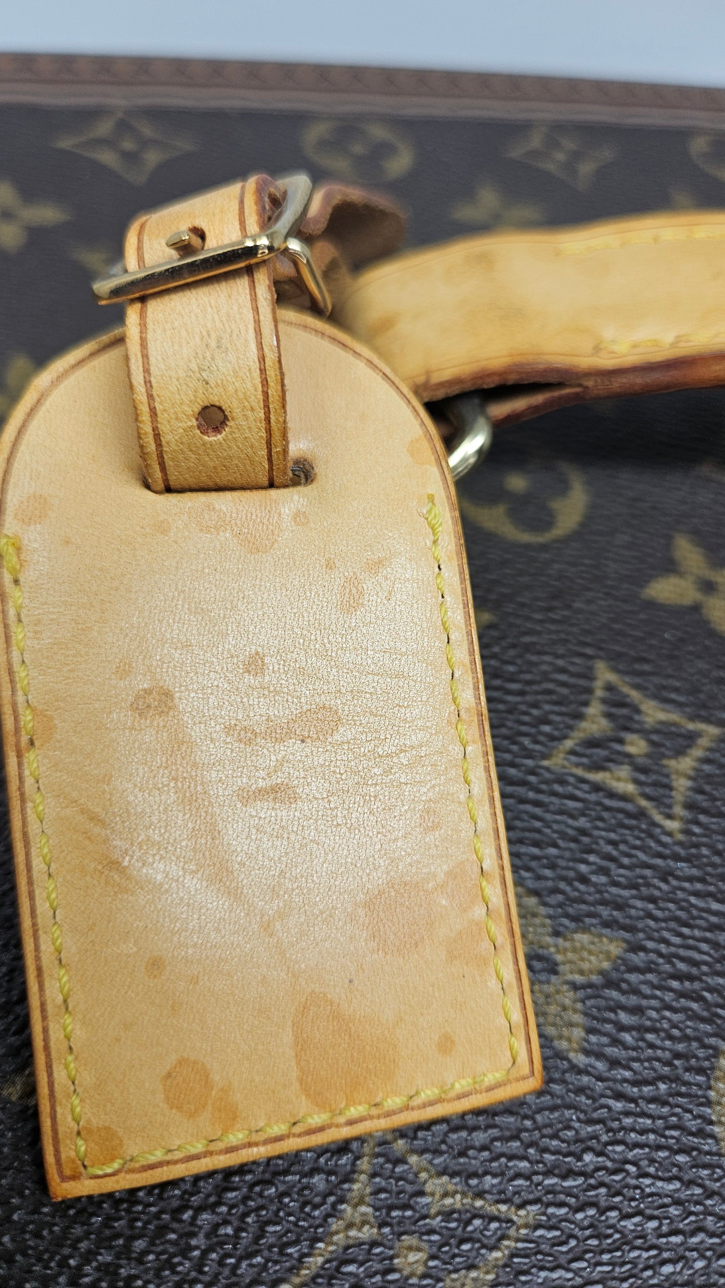 Close-up of a Louis Vuitton luggage tag with light water stain.