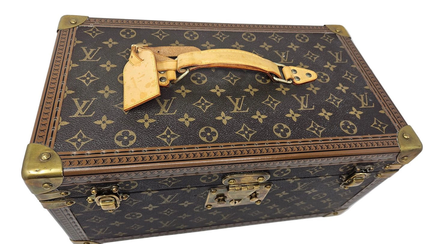 Louis Vuitton monogram suitcase with gold accents on a blue background