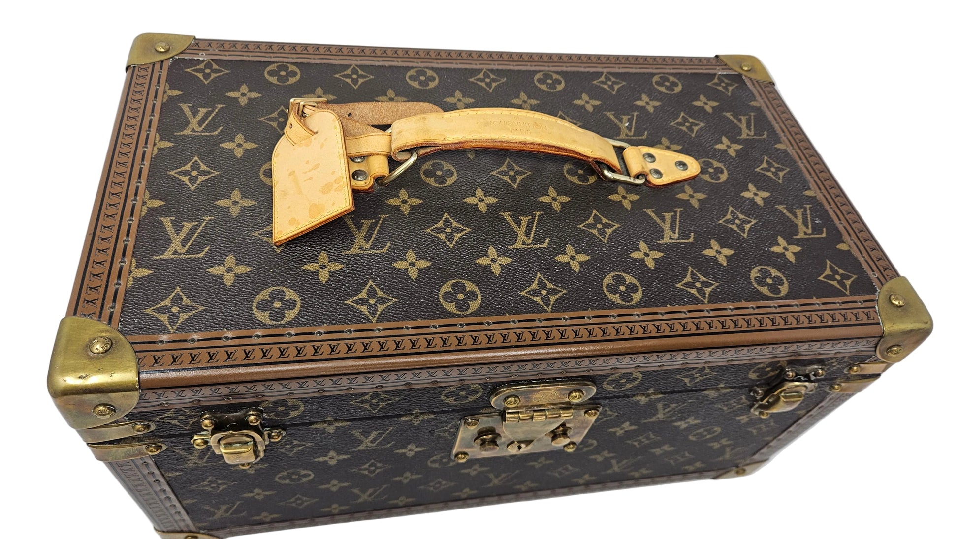Louis Vuitton monogram suitcase with gold accents on a blue background