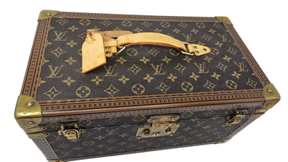 Louis Vuitton monogram suitcase with gold accents on a blue background