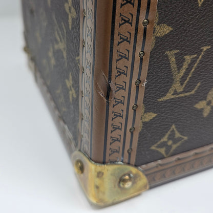 Close-up of a Louis Vuitton Vanity Case corner with monogram pattern and slight indent damage to the leather trim edge. 