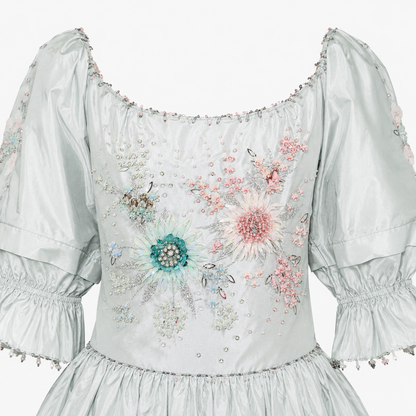 White dress with floral embroidery and embellishments on a white background