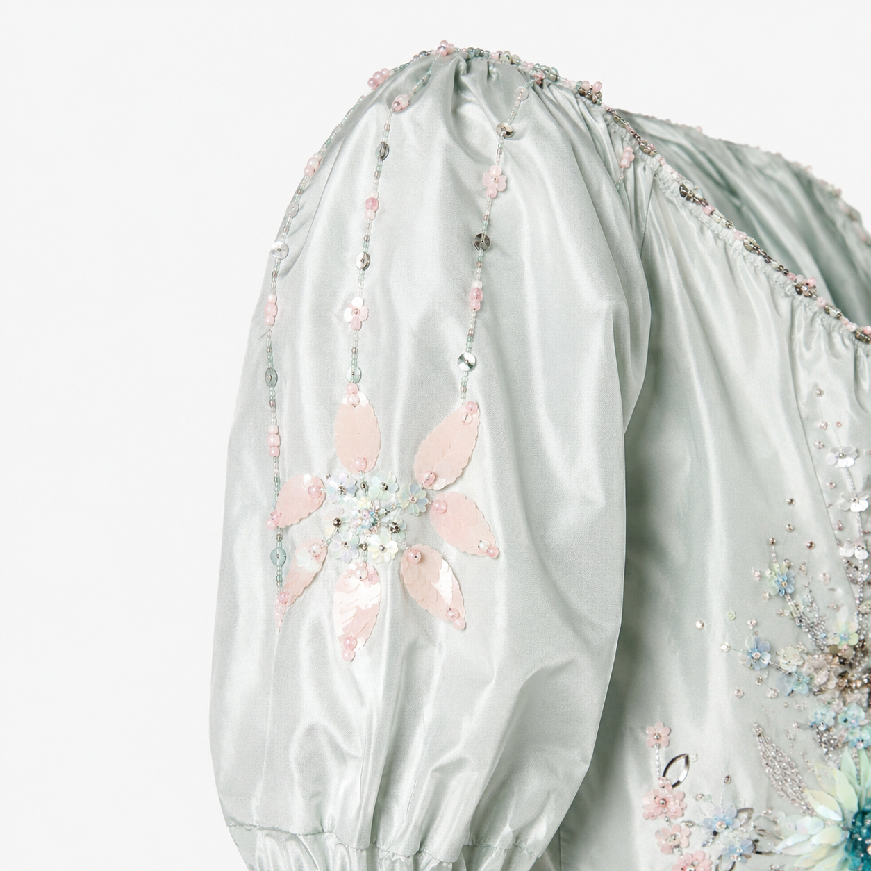 Light green blouse with floral embroidery on a white background