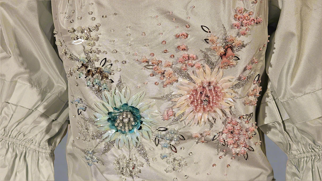 Elegant dress with floral embroidery and embellishments on a plain background