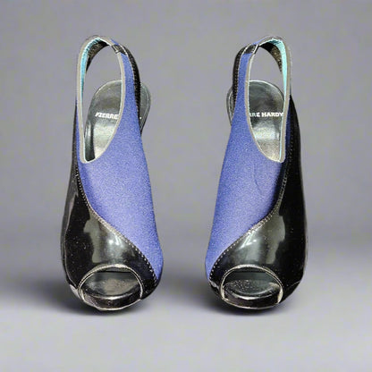 Pair of blue high-heeled shoes on clear stands against a gray background