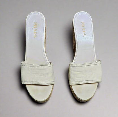 Pair of beige Prada sandals on a marble surface