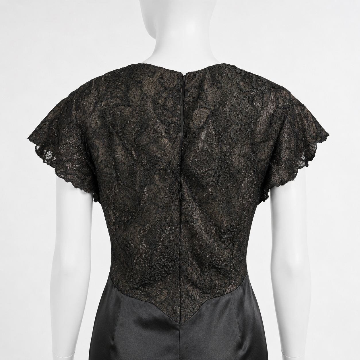 Black lace top on a mannequin against a white background