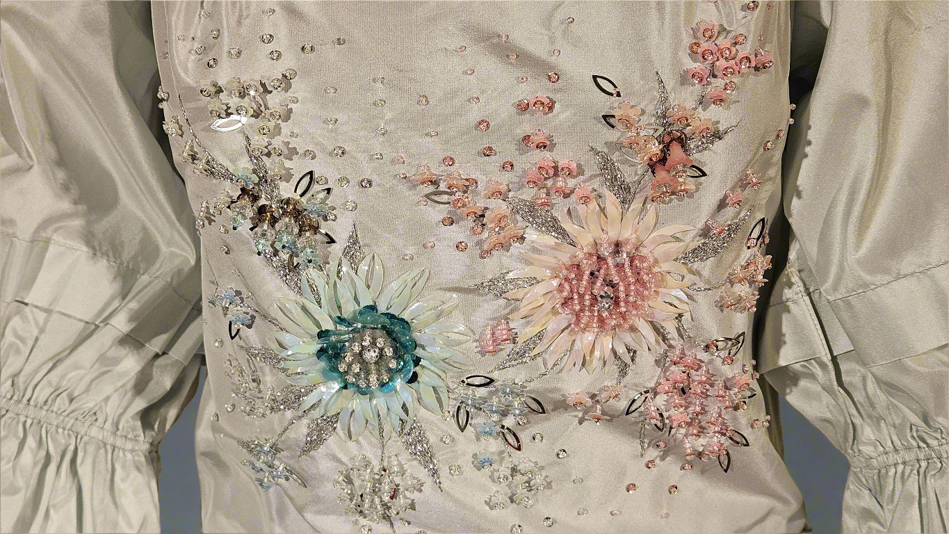 Elegant dress with floral embroidery and embellishments on a plain background