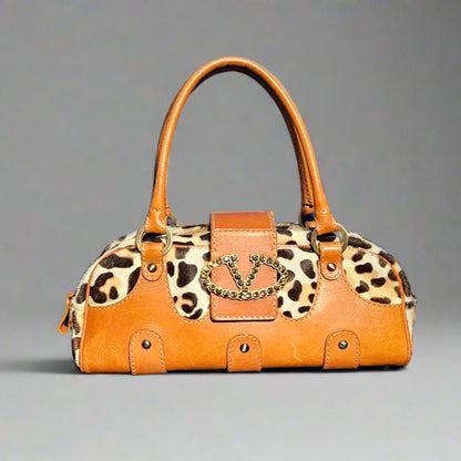 Orange handbag with leopard print pattern on a gray background