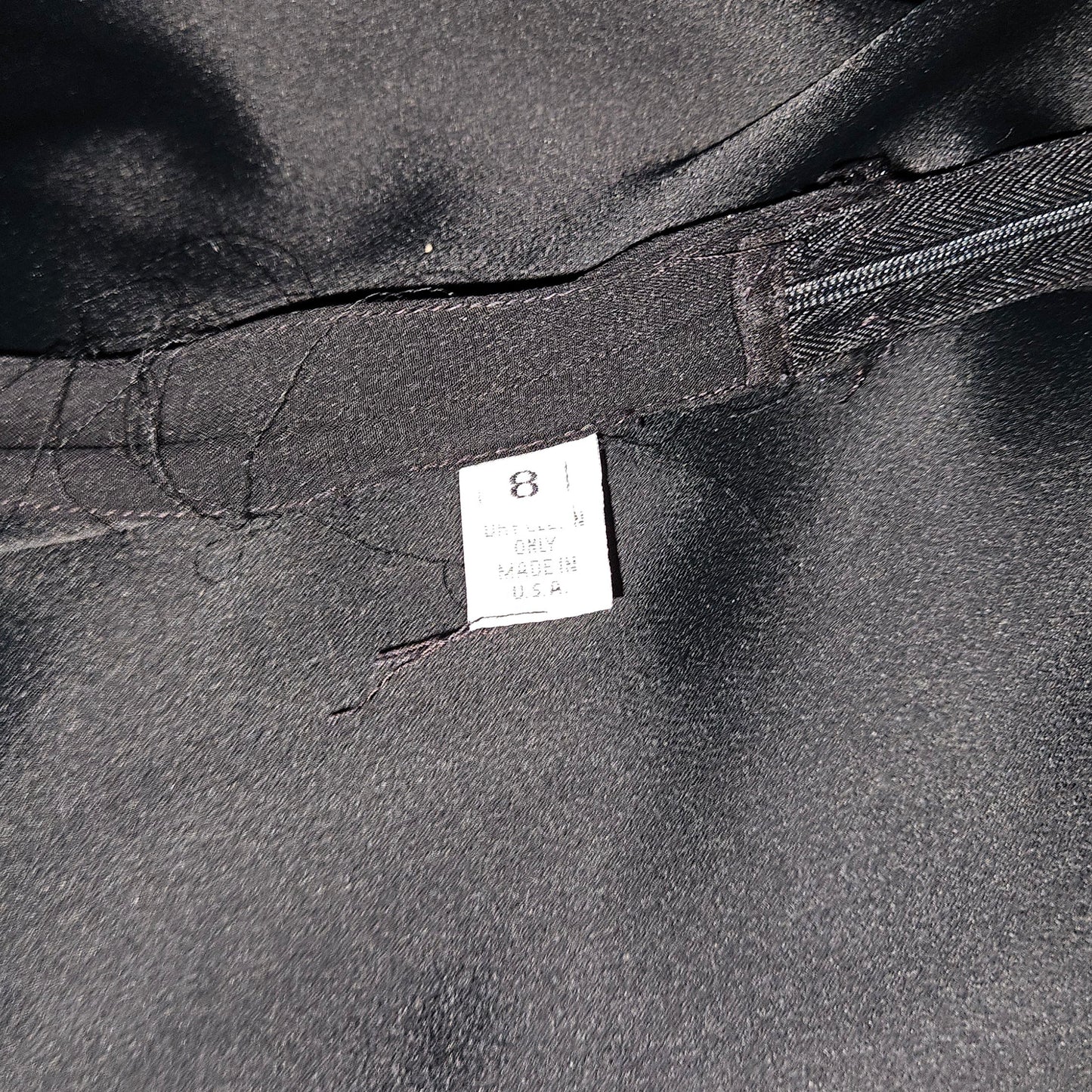 Close-up of a black garment with a label on a dark background
