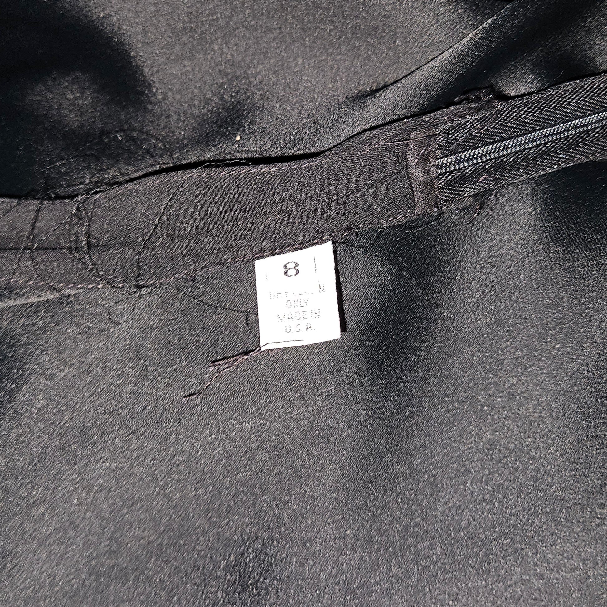 Close-up of a black garment with a label on a dark background