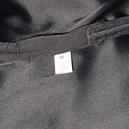 Close-up of a black garment with a label on a dark background