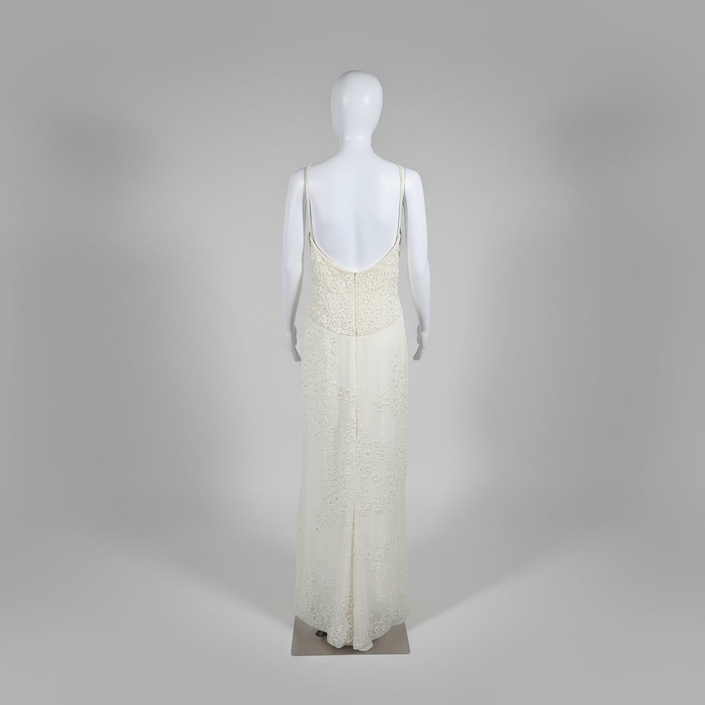 Mannequin wearing a long, light-colored dress against a plain background