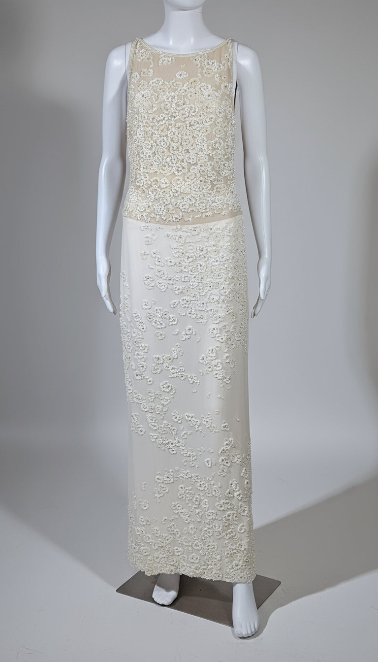 White lace evening gown on a mannequin against a plain background