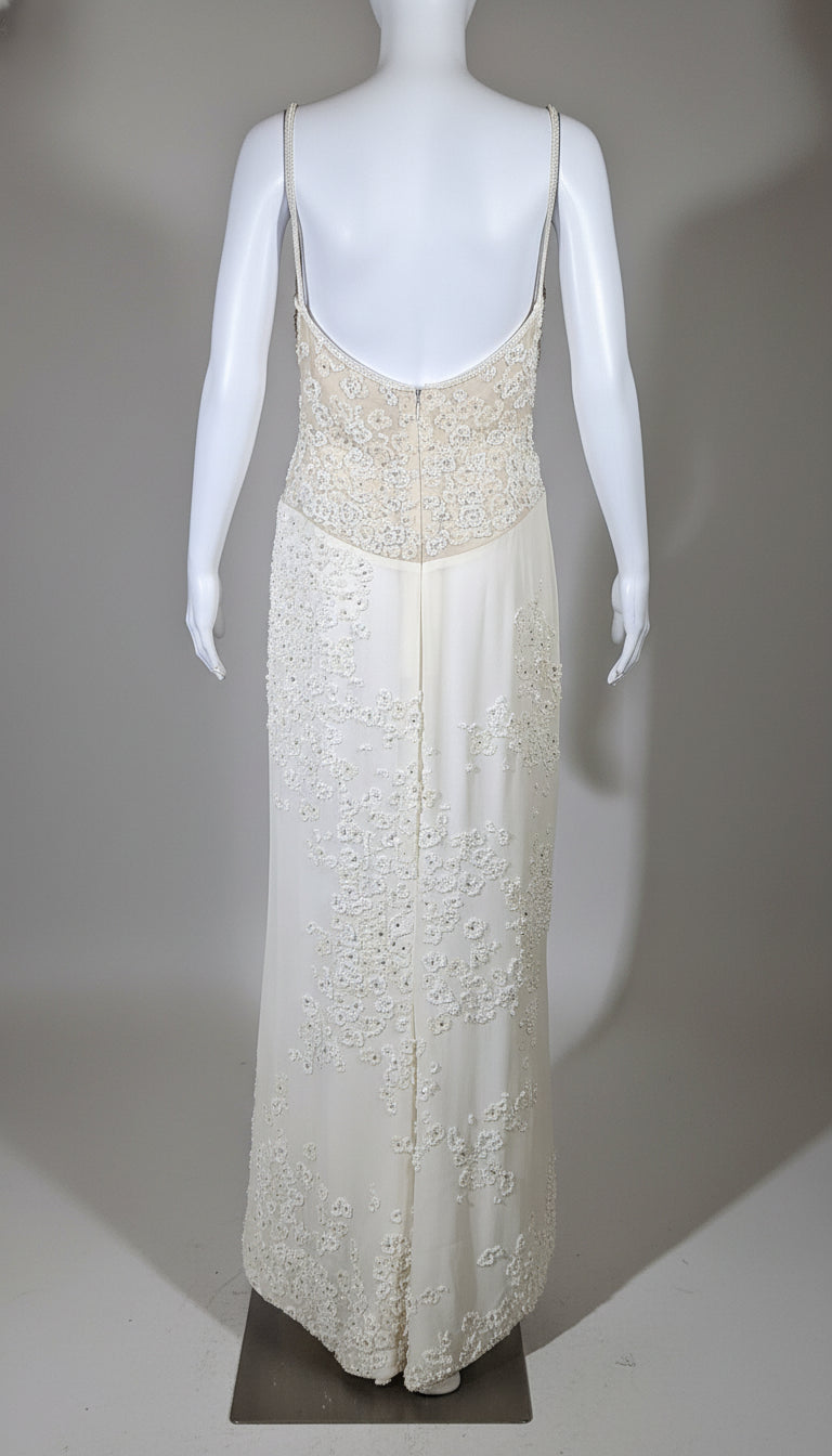 White lace evening gown on a mannequin against a gray background