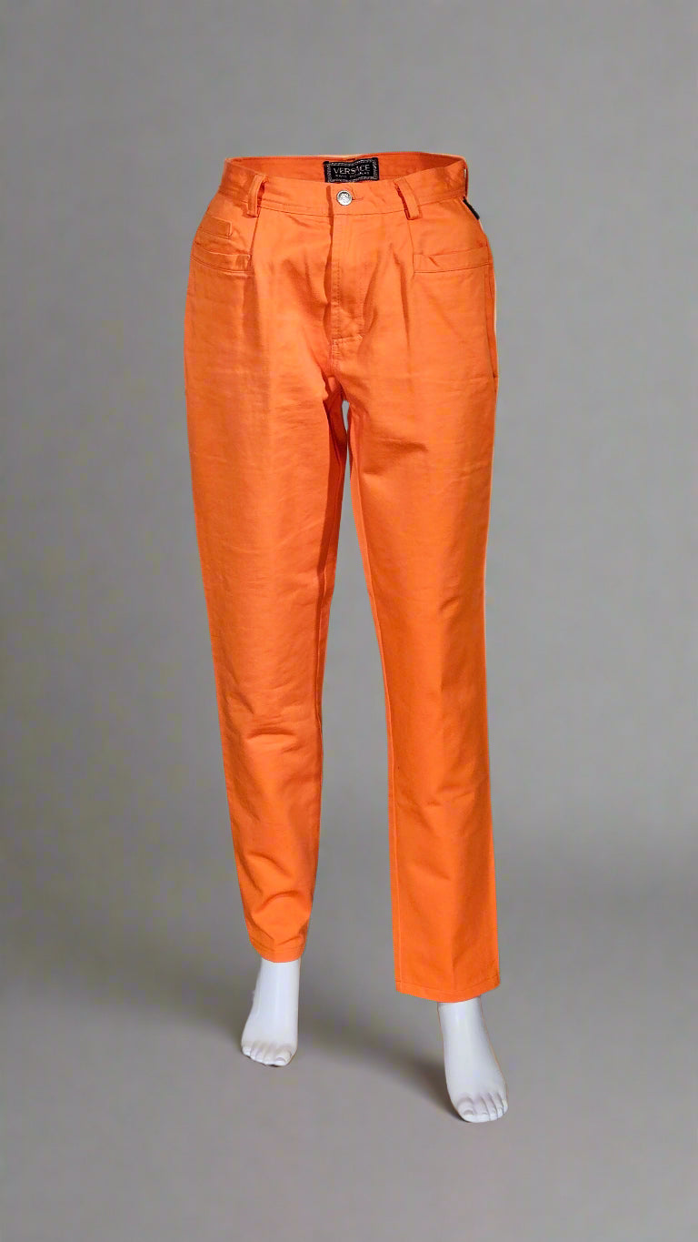 Orange pants displayed on a mannequin against a neutral background