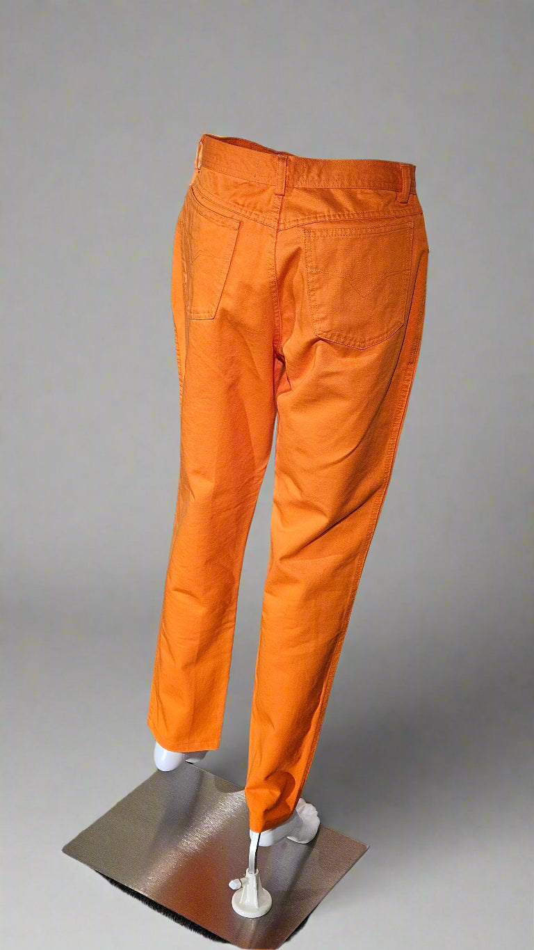 Orange pants on a mannequin against a gray background