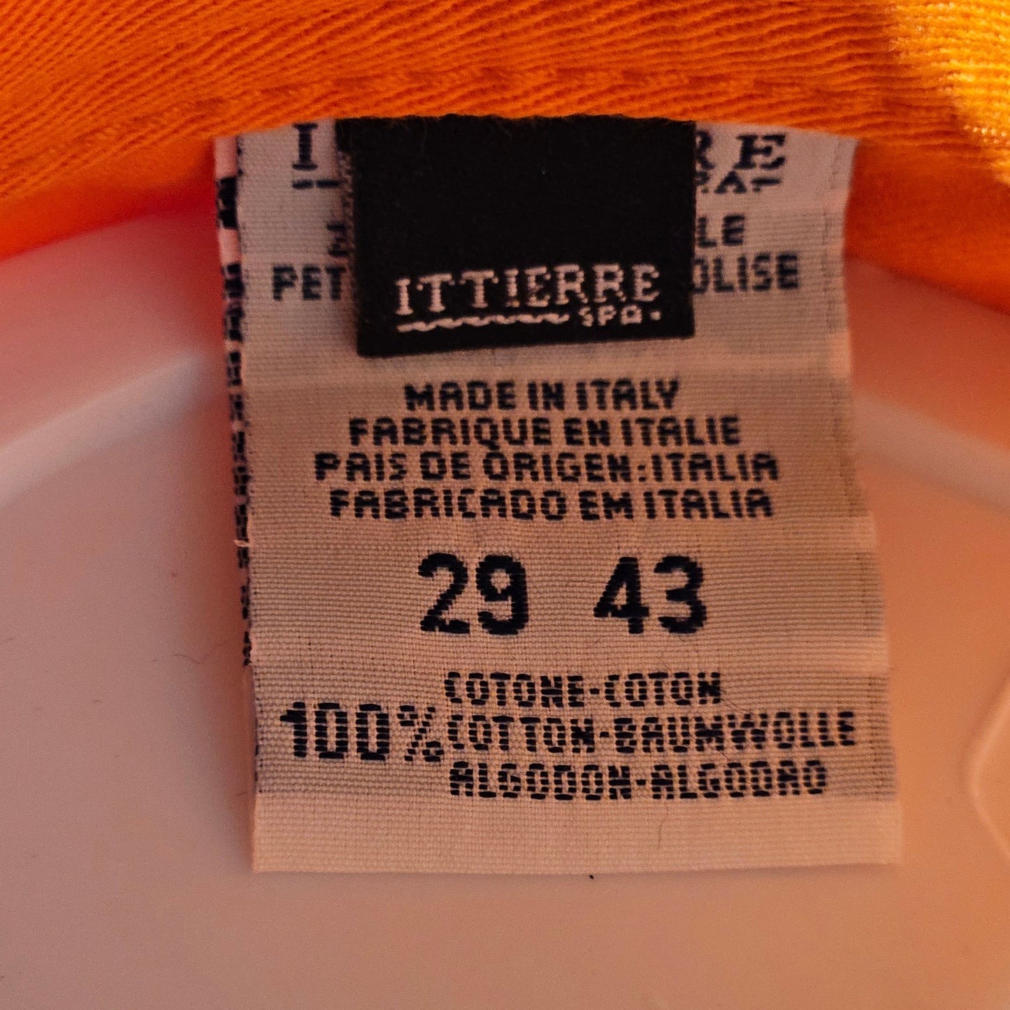 Fabric tag with size and material information on an orange fabric background