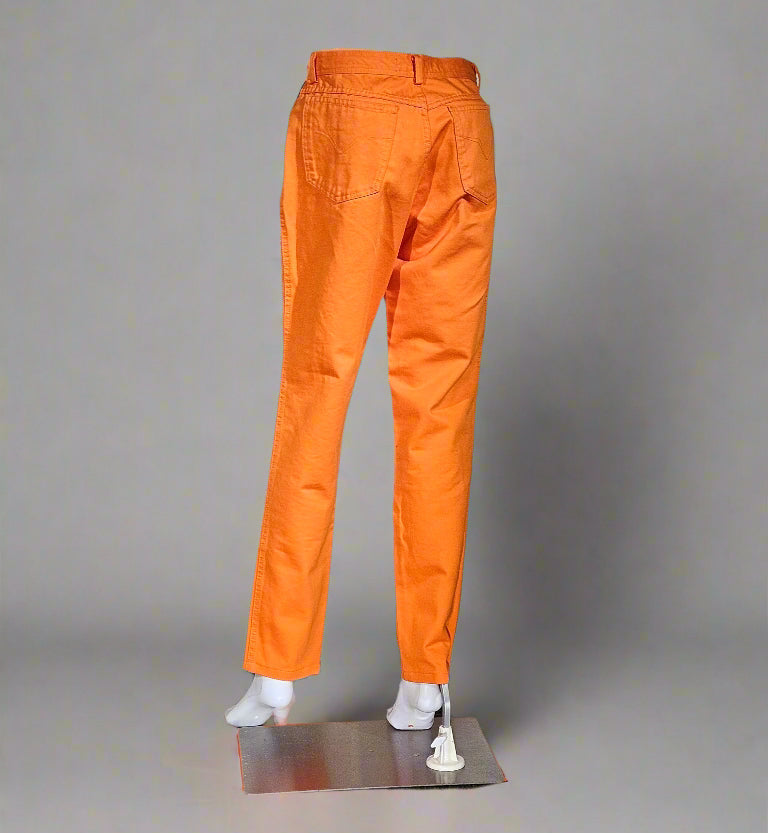 Orange pants on a mannequin against a gray background