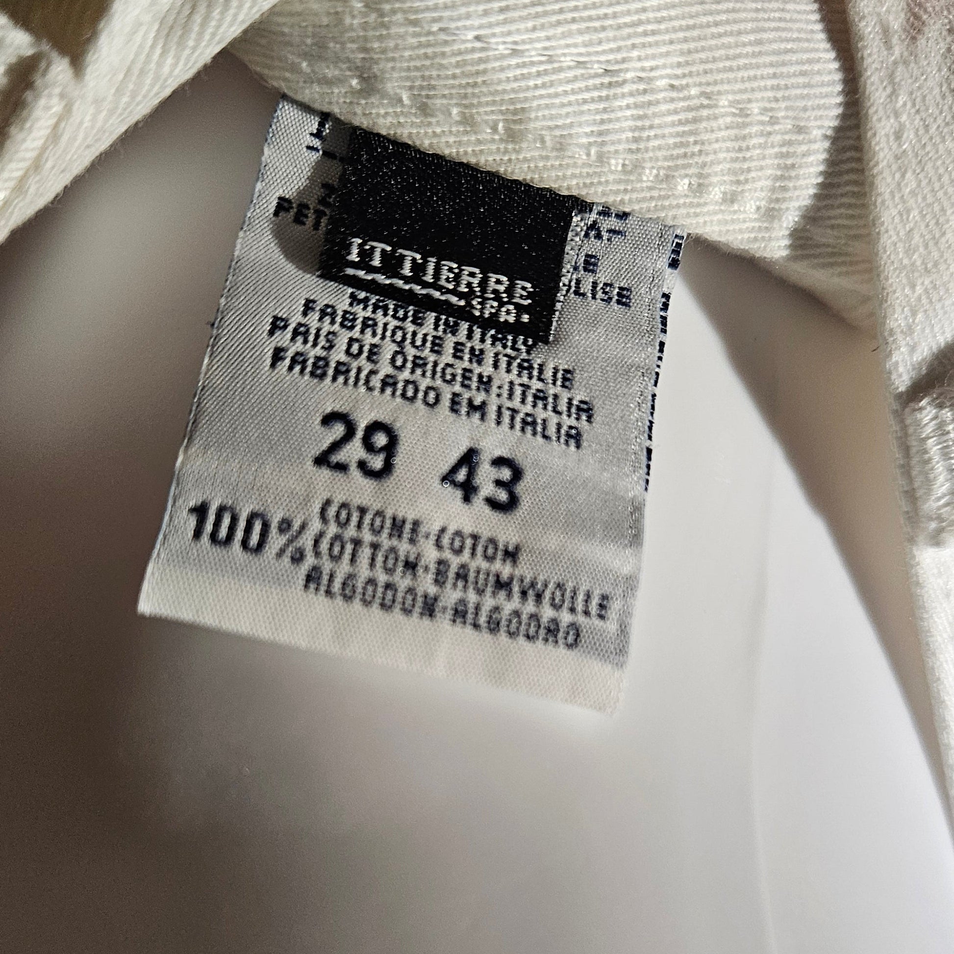 Close-up of a clothing tag with size information on a blurred background