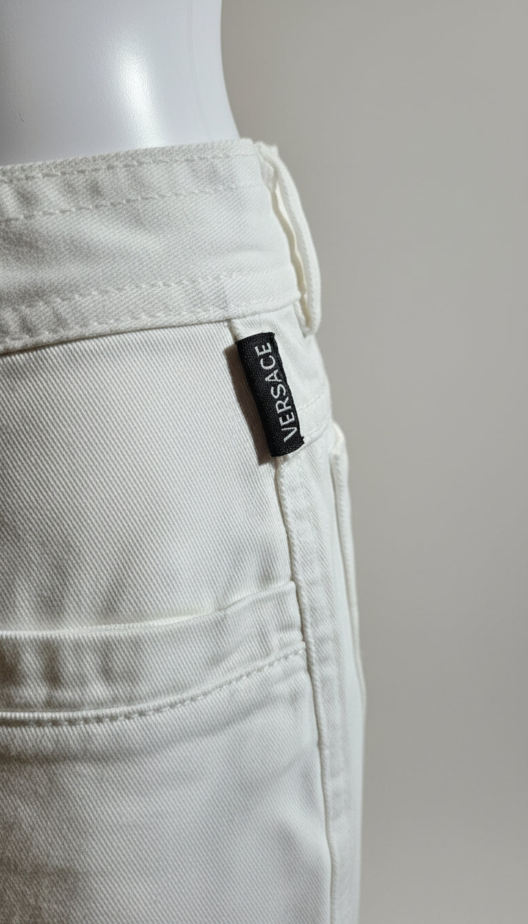 White Versace pants with a visible label on a gray background