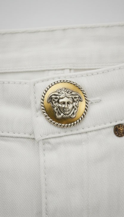 Round metal button with a design on a fabric background