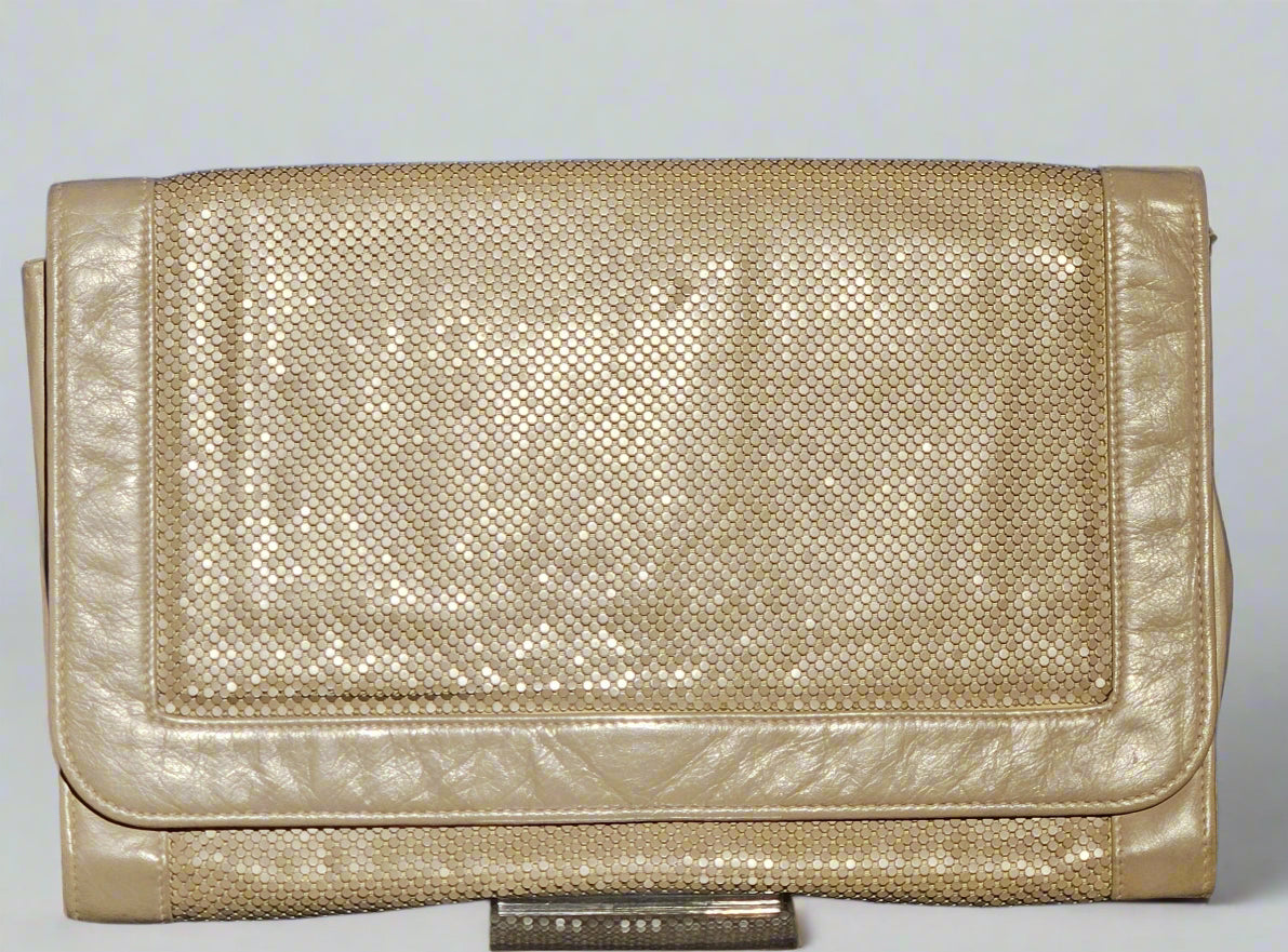 Gold metallic clutch bag on a light gray background