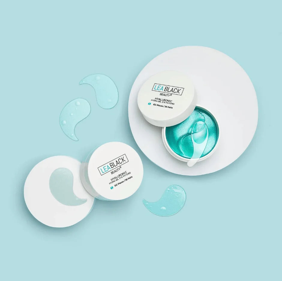 Two white cosmetic jars of LEA BLACK Beauty sheet masks with turquoise gel, arranged on a light blue background with matching gel patches.
