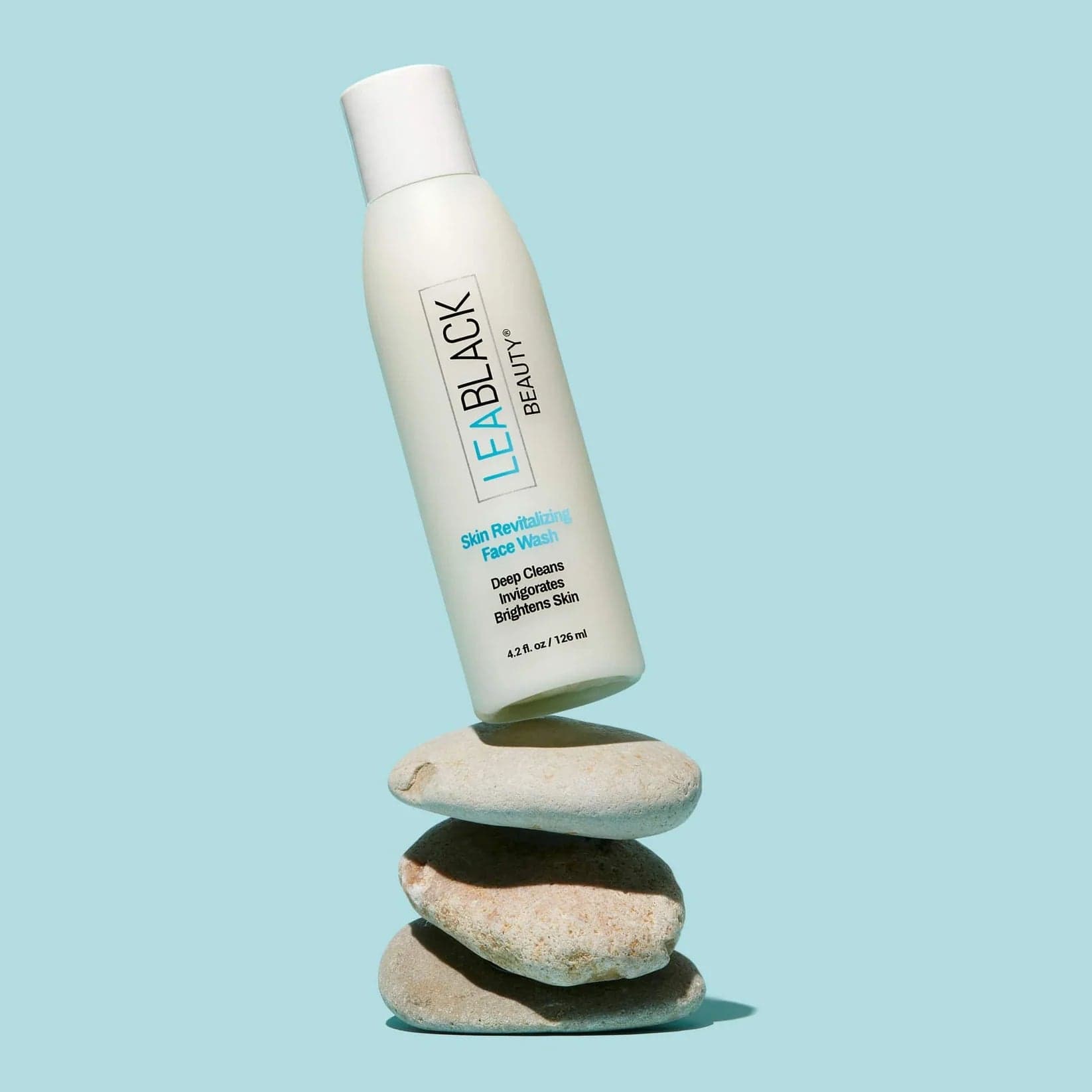A bottle of Lea Black Beauty® Skin Revitalizing Daily Face Wash on a stack of three stones