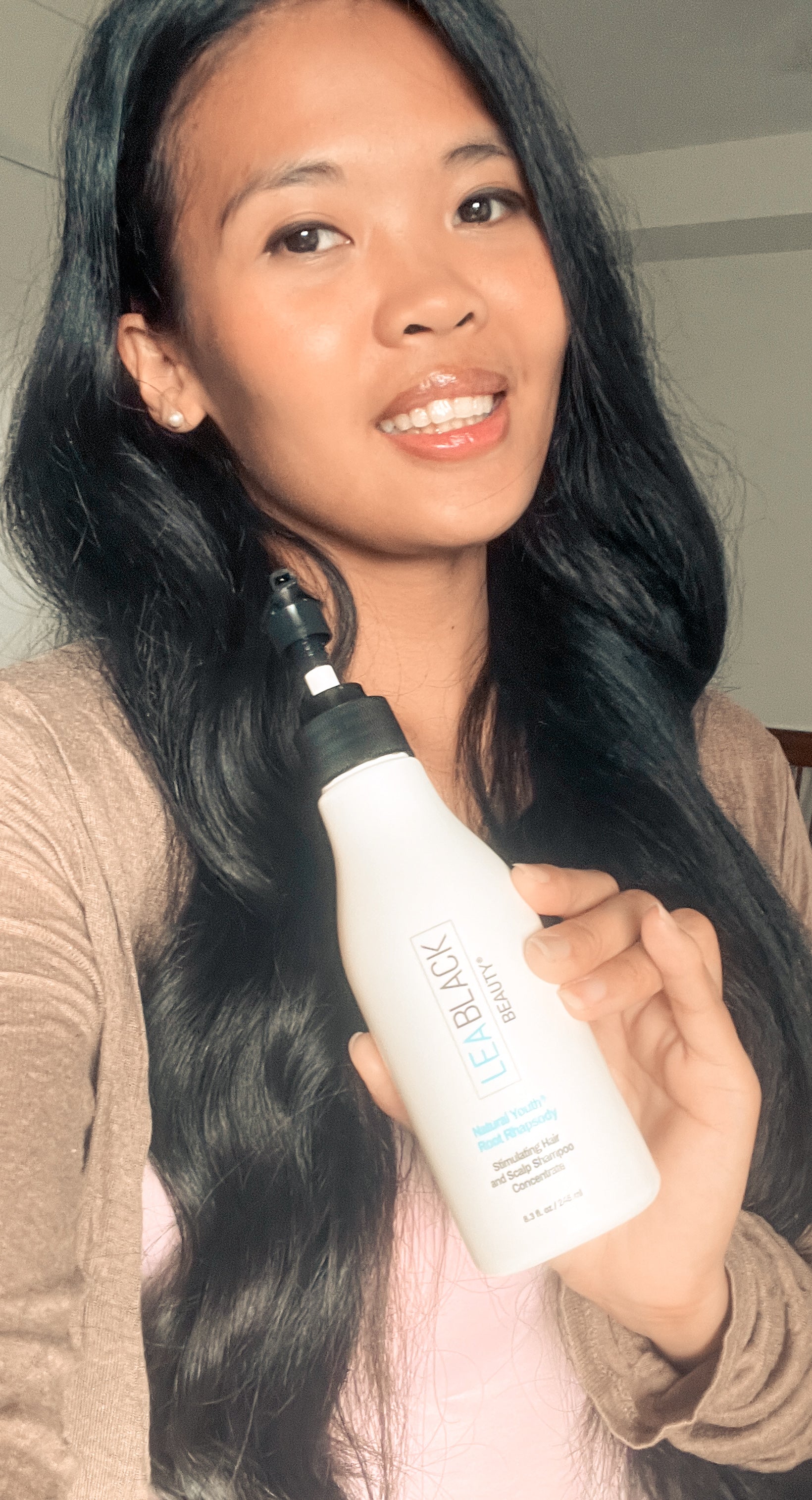 Pri washing her long dark hair with Natural Youth Root Rhapsody Shampoo Concentrate and displaying the soft, shiny finished results.