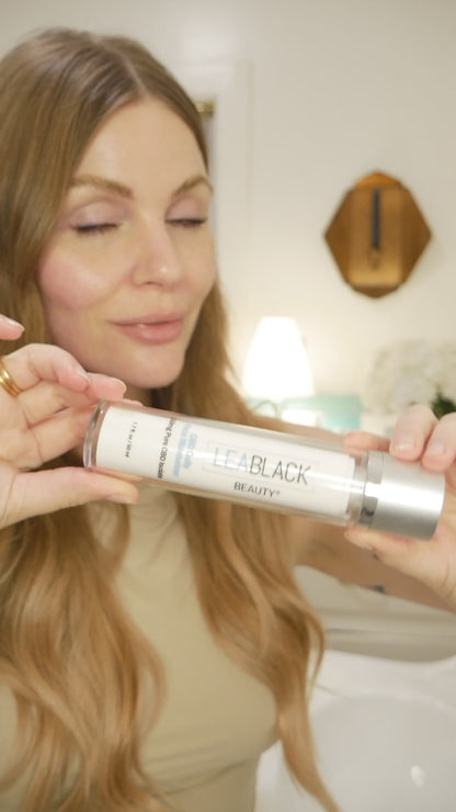 Leslie dispensing and applying Lea Black Beauty 150mg CBD Daily Face Moisturizer across her face.